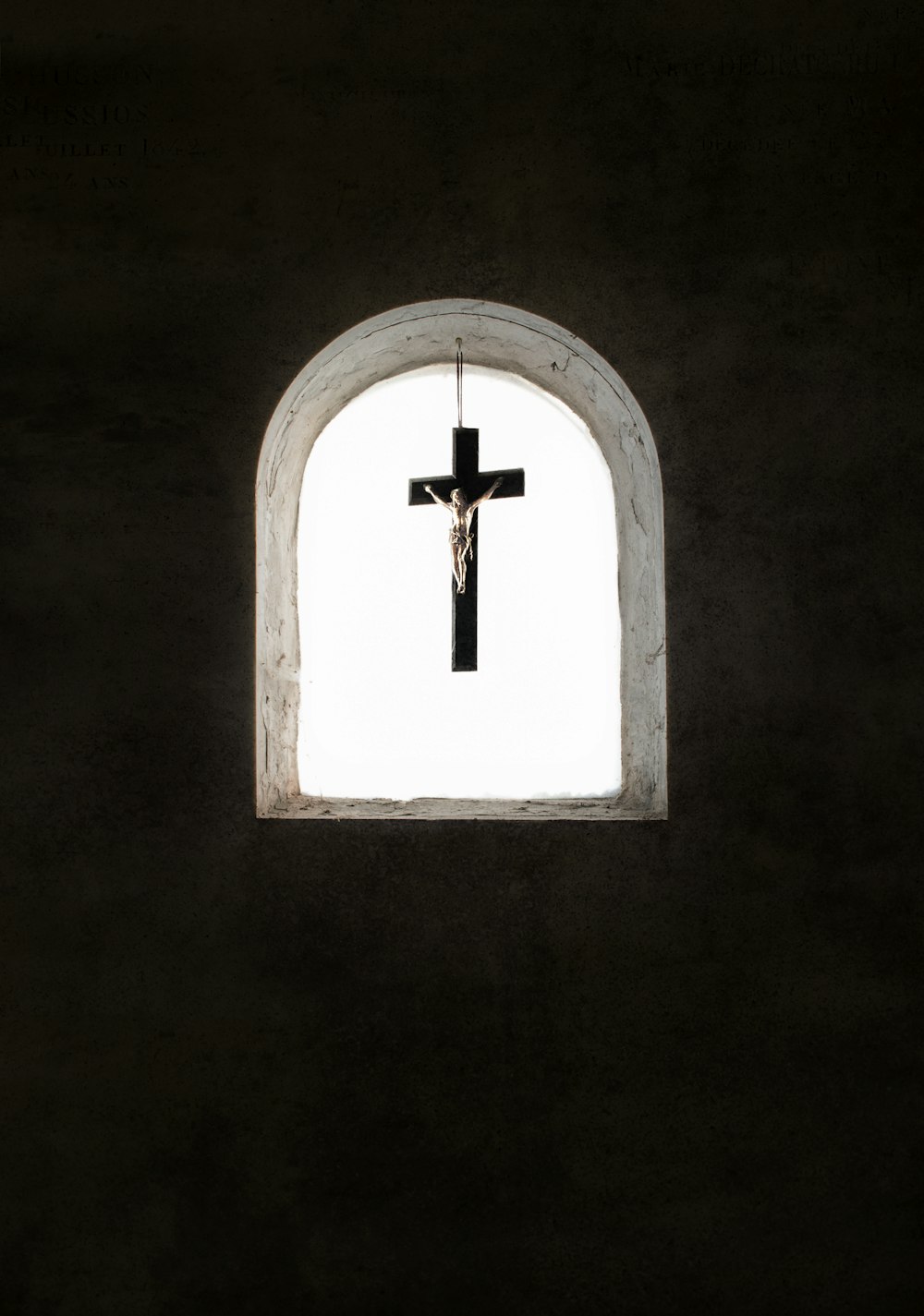 a cross hanging from the side of a wall