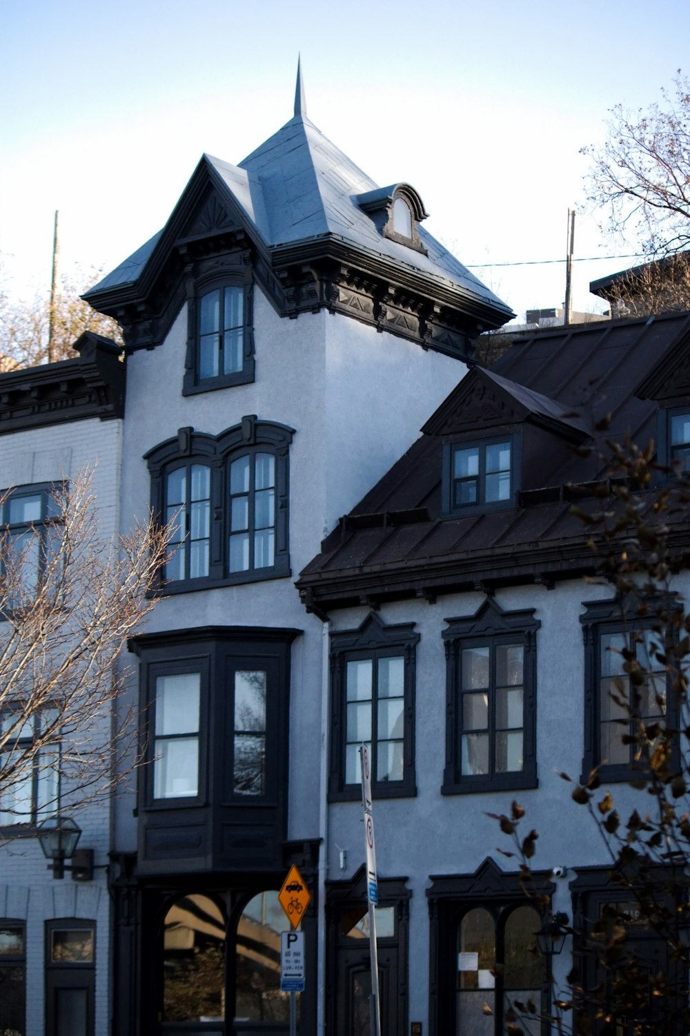 a tall white building with a black roof