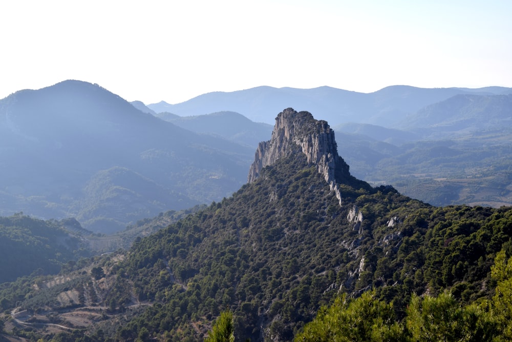 a view of a mountain range with trees and mountains in the background