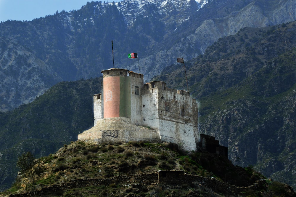 a castle with a flag on top of a mountain