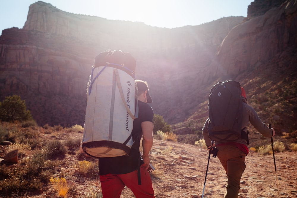 a couple of people walking down a dirt road