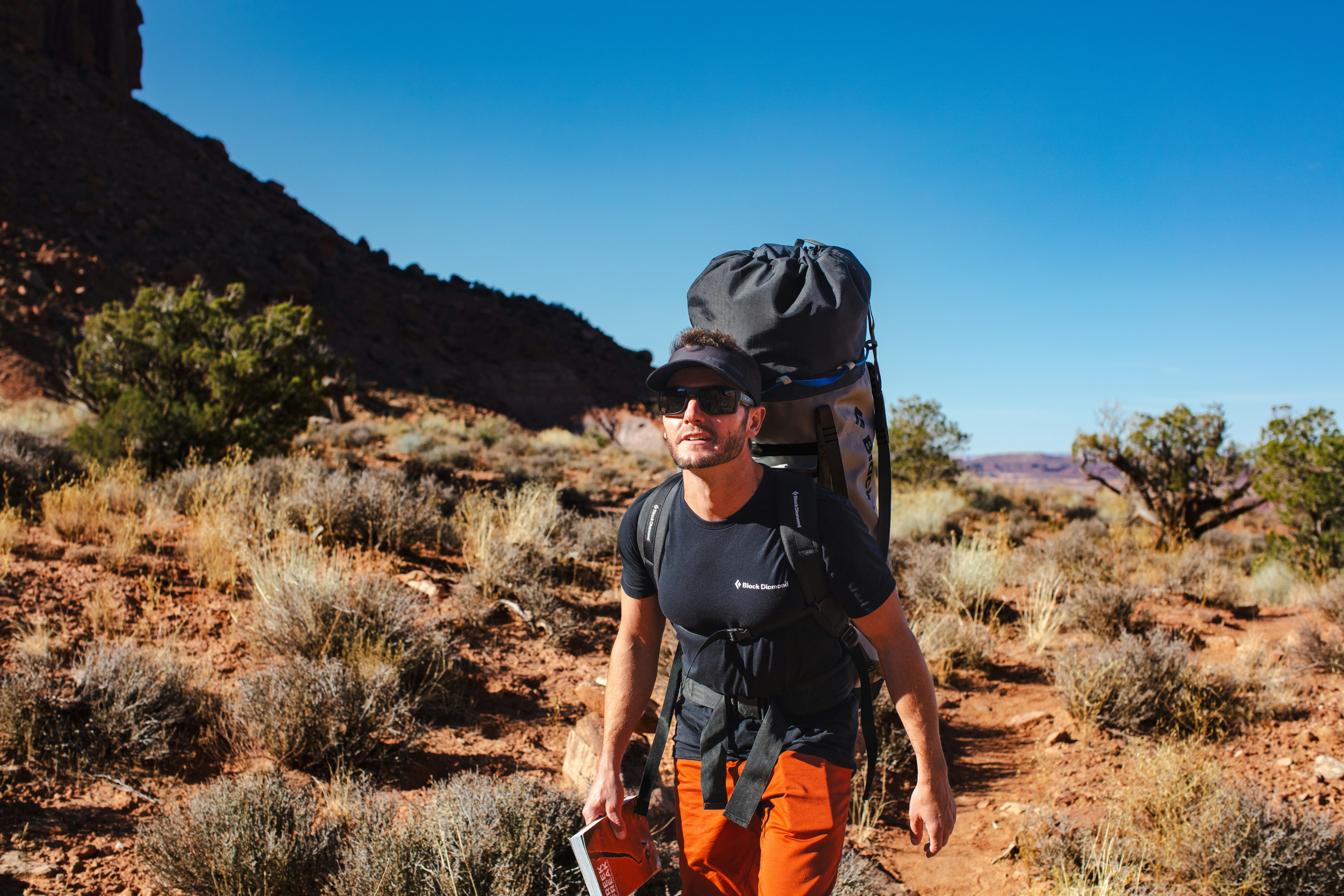 a man with a backpack and a camera in the desert