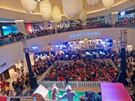 A lively kids' fashion show event hosted inside the mall with smiling children on the runway.