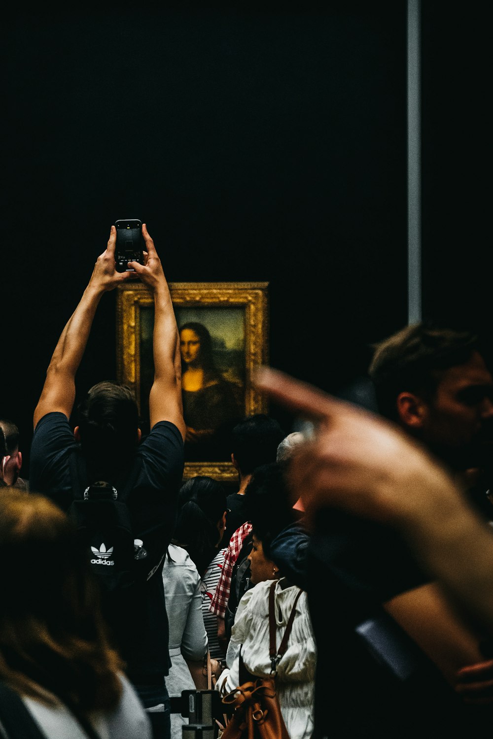 a group of people taking pictures of a painting