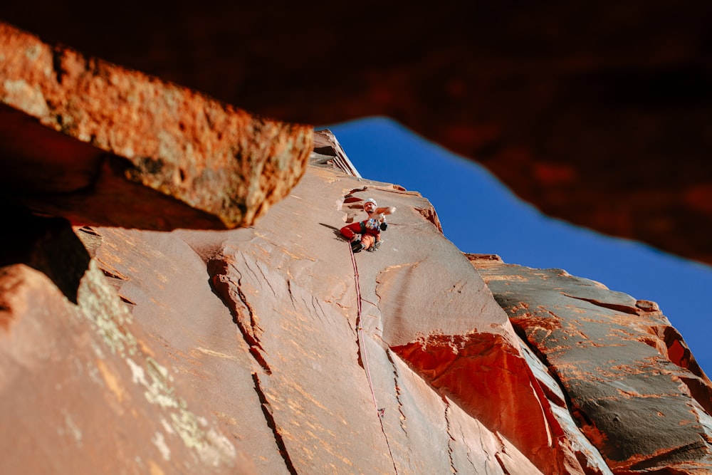 a man climbing up the side of a mountain