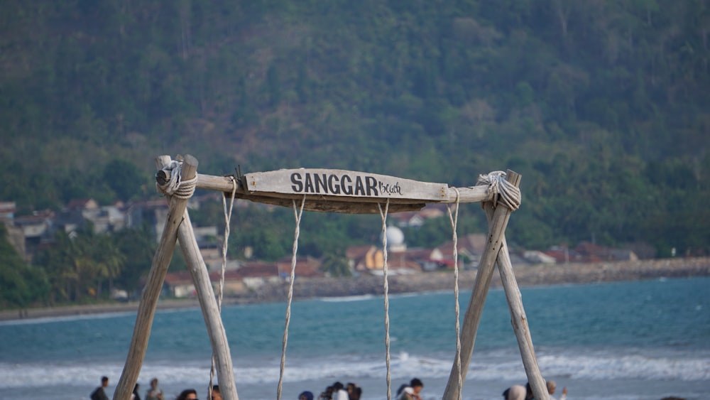 a group of people standing around a wooden swing