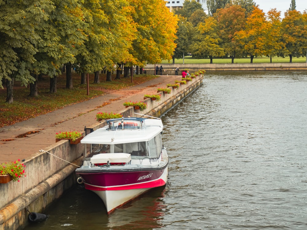 Un bateau rouge et blanc est amarré à un quai