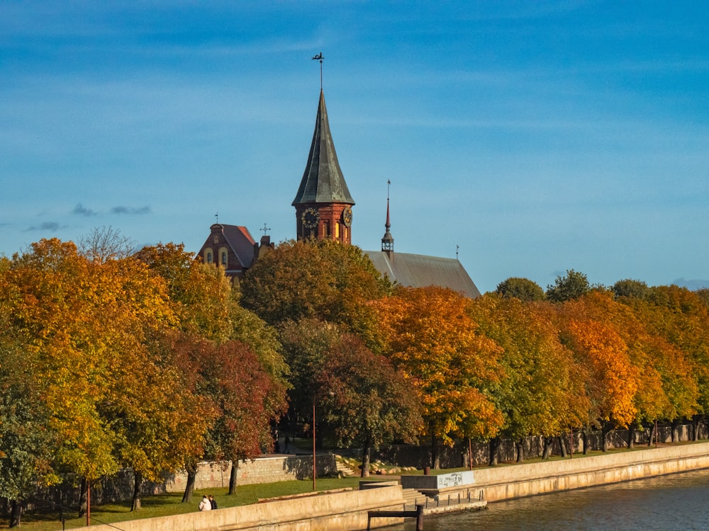 a church on a hill next to a body of water