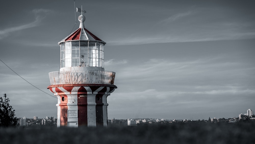 a red and white lighthouse on a cloudy day