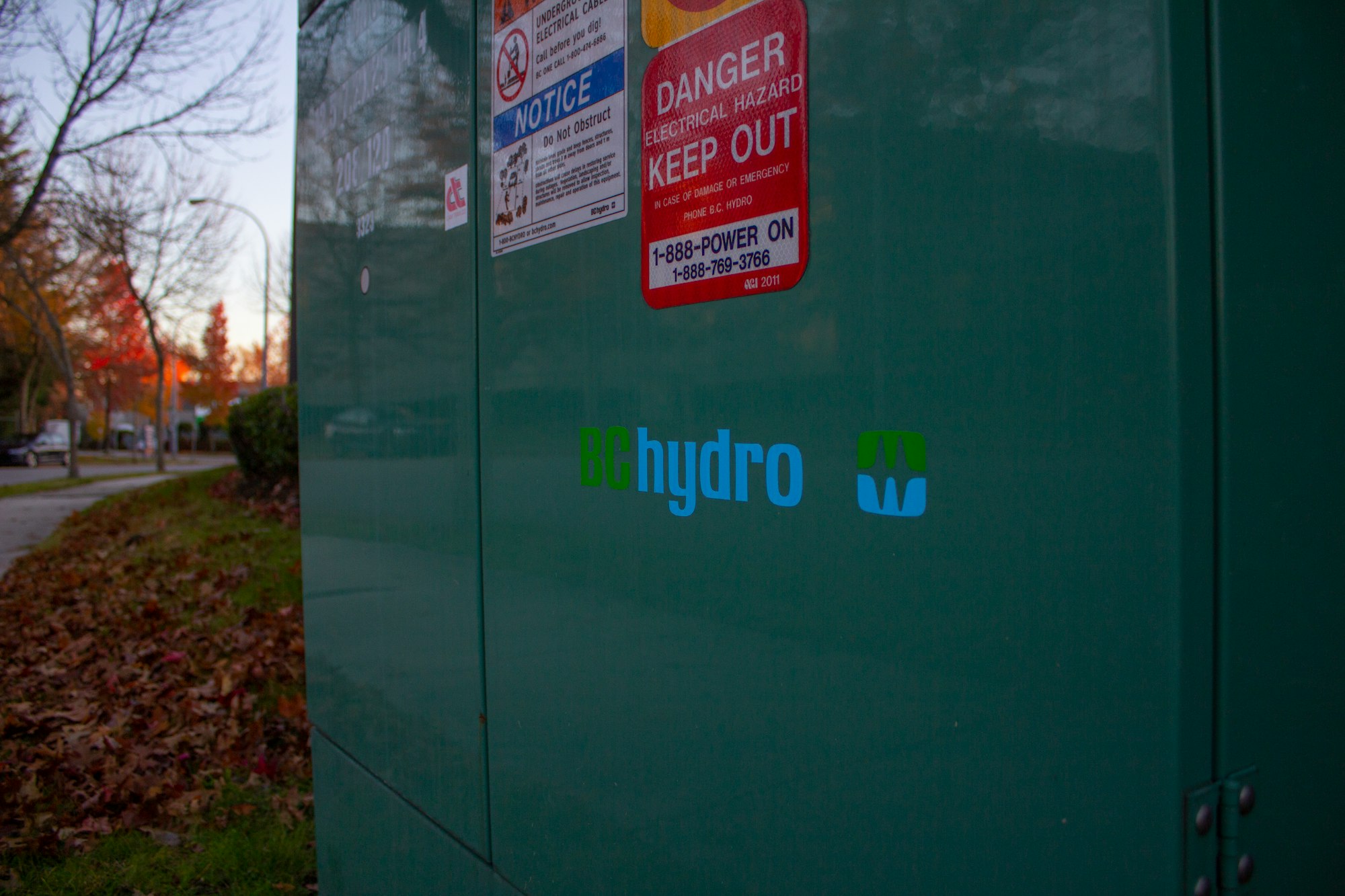 a green metal box with a sign on it