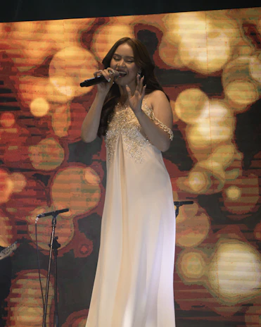 Portrait of a soprano singer performing passionately on stage in elegant attire