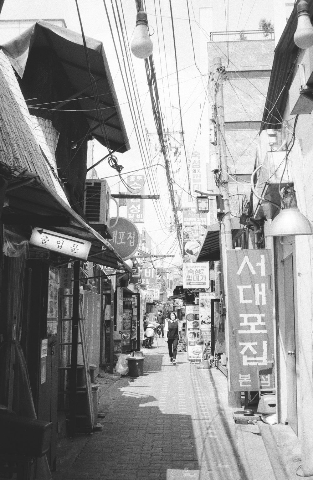 a black and white photo of a narrow street