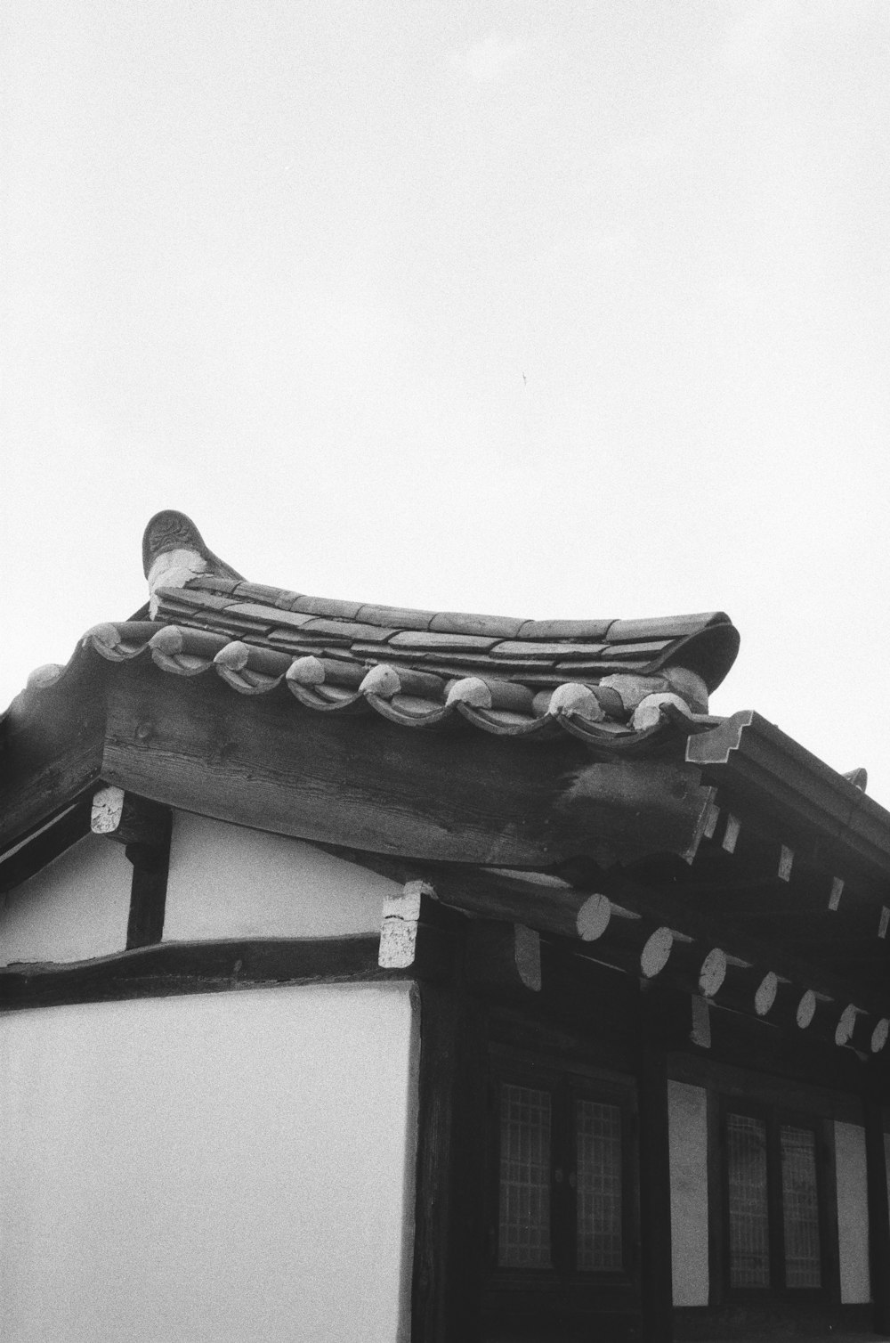 ein Schwarz-Weiß-Foto eines Gebäudes mit Dach