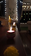 A cozy pooja decoration with traditional lamps, flowers, and elegant drapes in warm tones