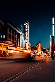 A vibrant street scene on Queen Street West glowing with neon signs and blurred motion of passing cars at night
