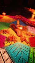 A minimalist white floor adorned with a delicate gold-accented rangoli kit ready for a housewarming celebration.