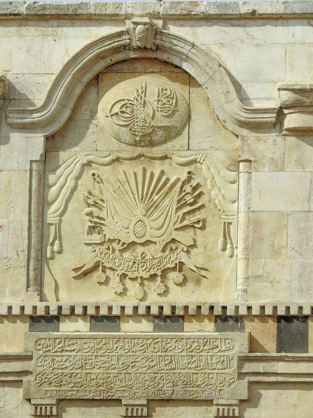 a stone wall with a coat of arms on it