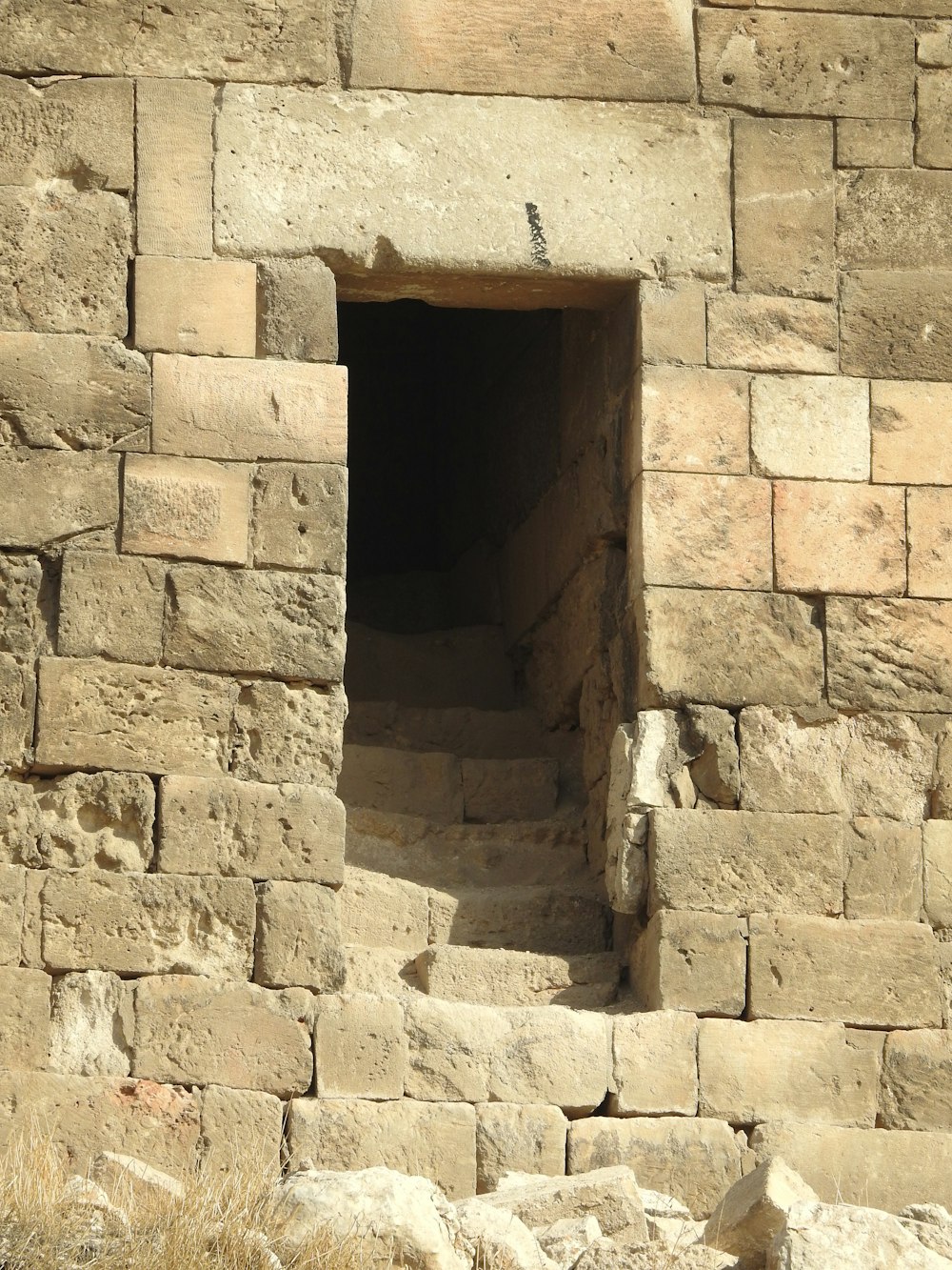 a stone wall with a small window in it
