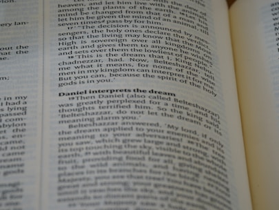 A close-up of an open book, with emphasis on a section discussing Daniel interpreting a dream. The text is in English and the page appears slightly curved.