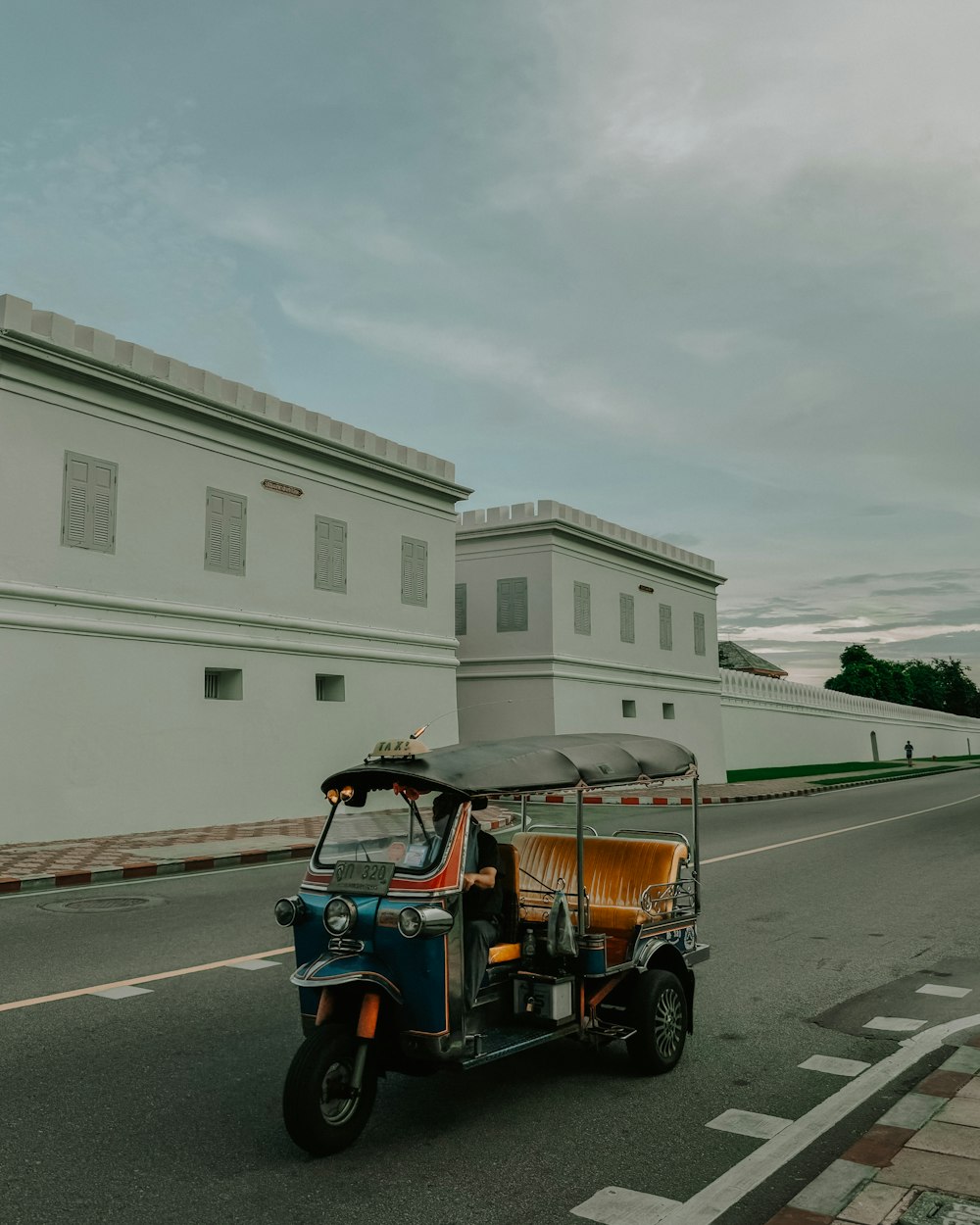 a man driving a three wheeled vehicle down a street