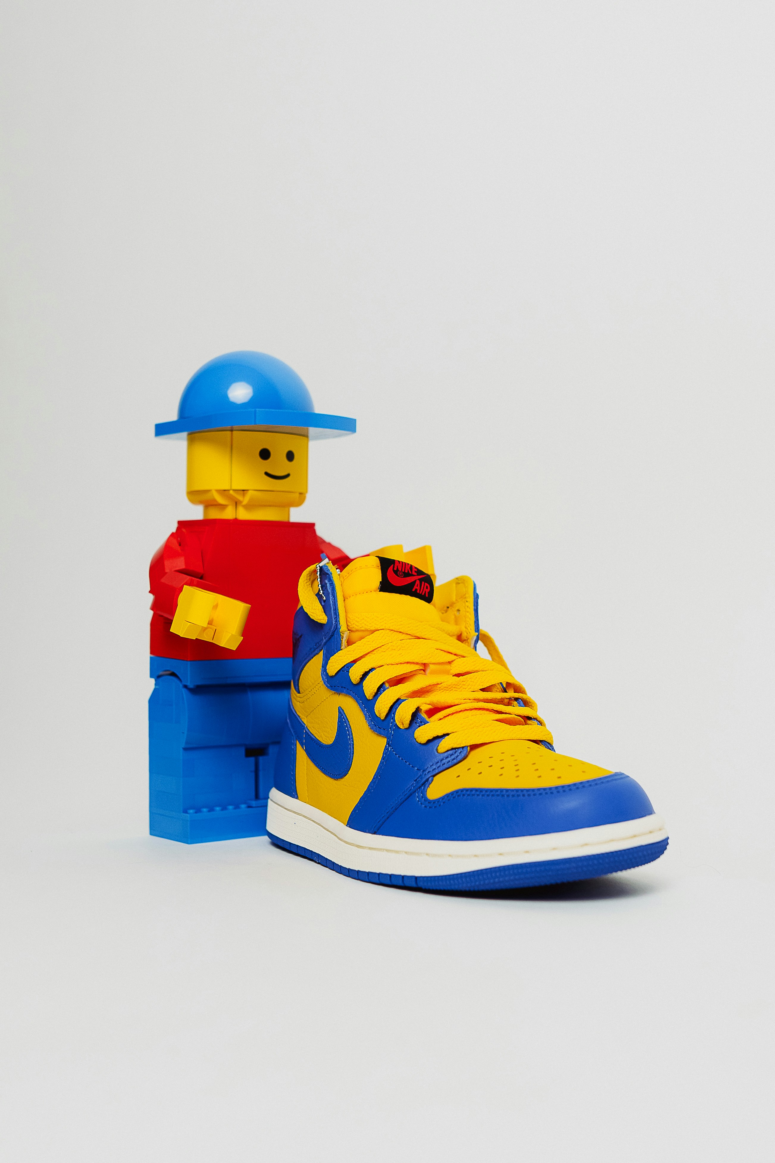Une chaussure jaune et bleue avec un homme Lego sur le dessus
