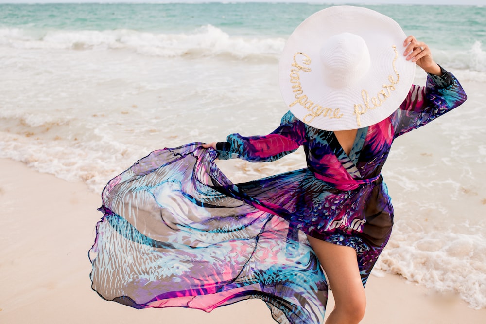 a woman with a hat walking on the beach