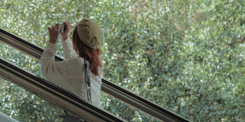 a woman standing on an escalator taking a picture