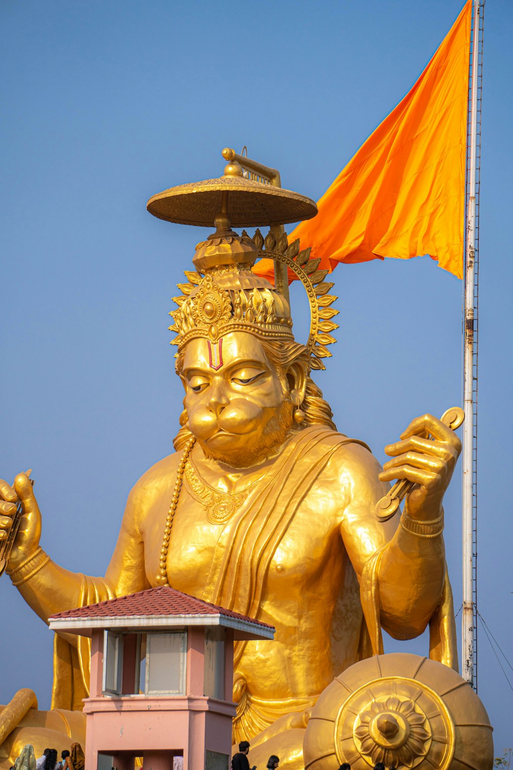 uma grande estátua dourada com uma bandeira em cima dela