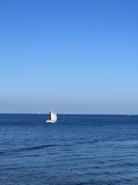 A sleek sailboat navigating calm blue waters under a clear sky, symbolizing smooth digital journeys.