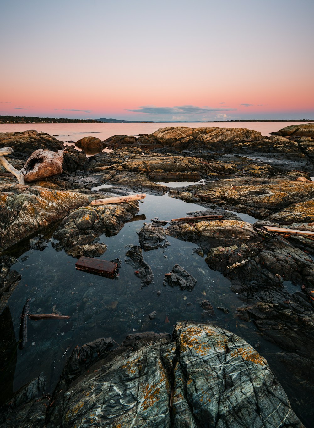 a body of water sitting on top of a rocky beach