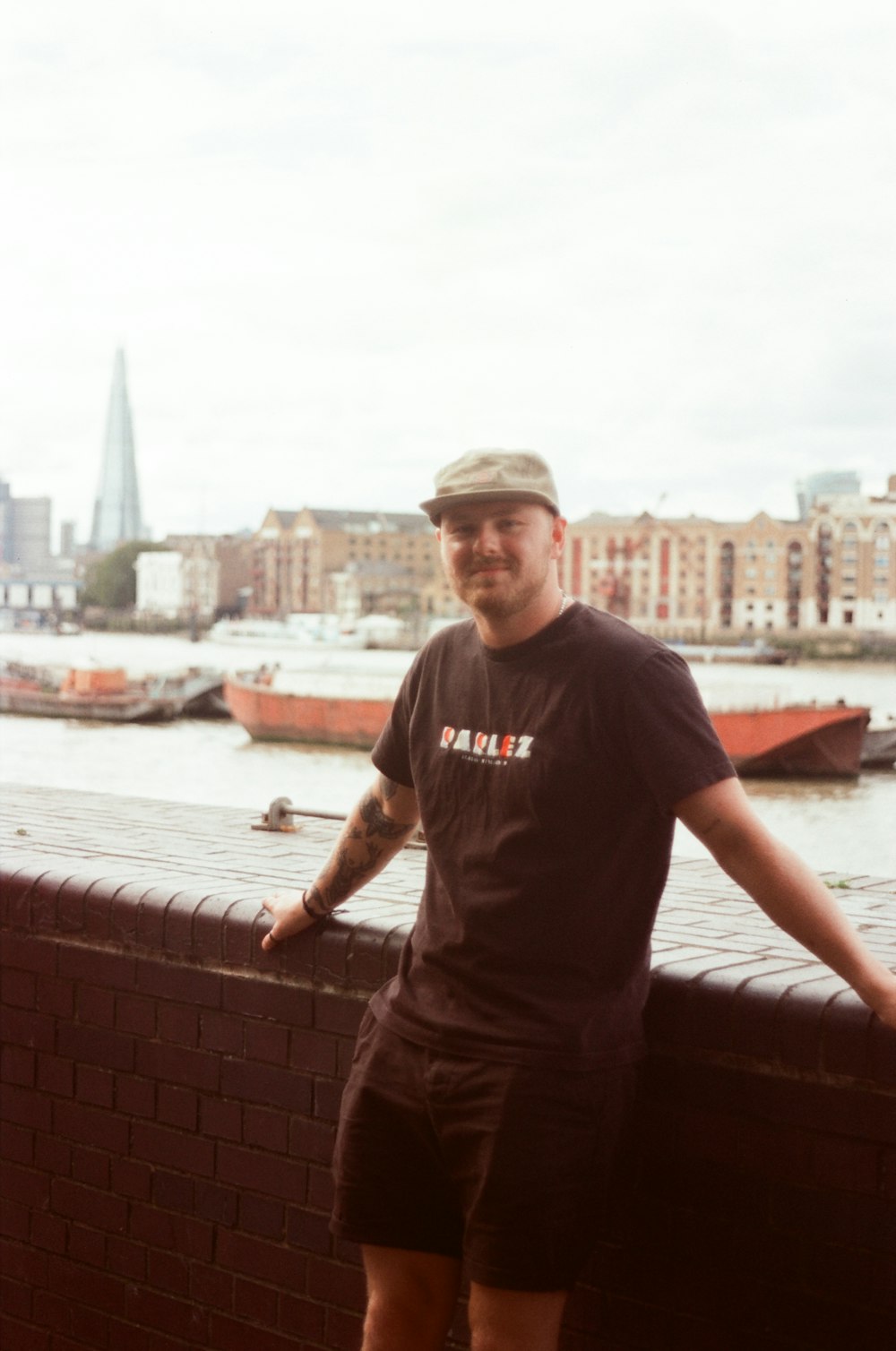 a man standing on a brick wall next to a body of water