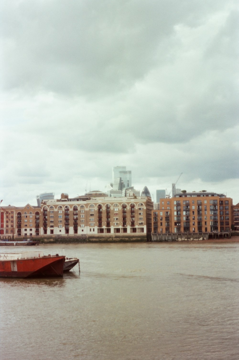 a boat floating on top of a river next to tall buildings