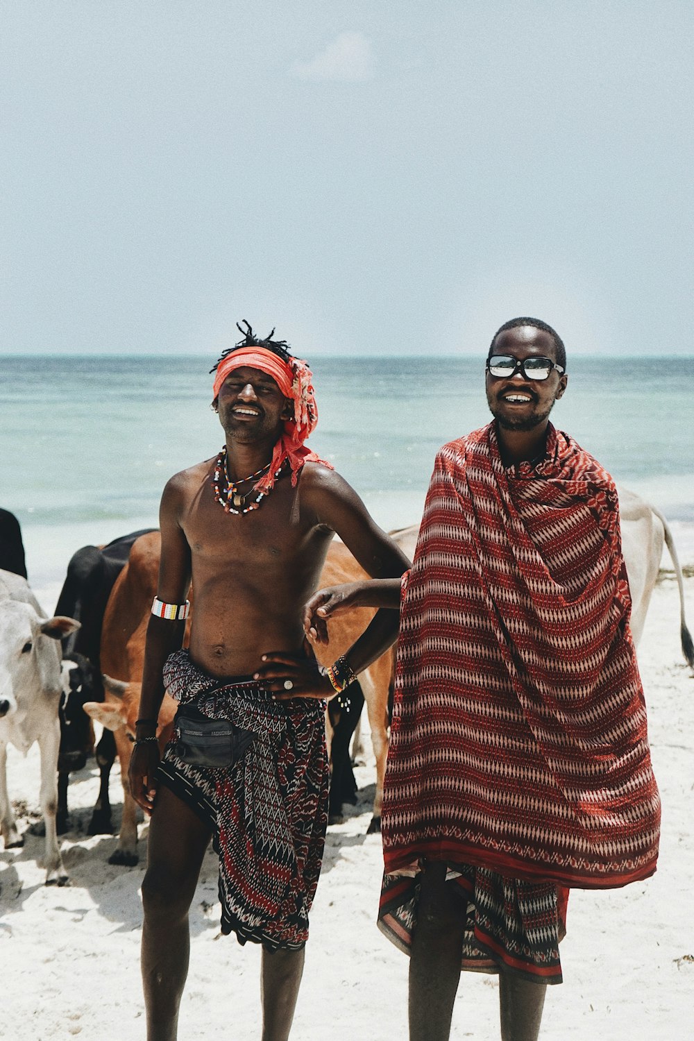 a couple of men standing next to each other on a beach