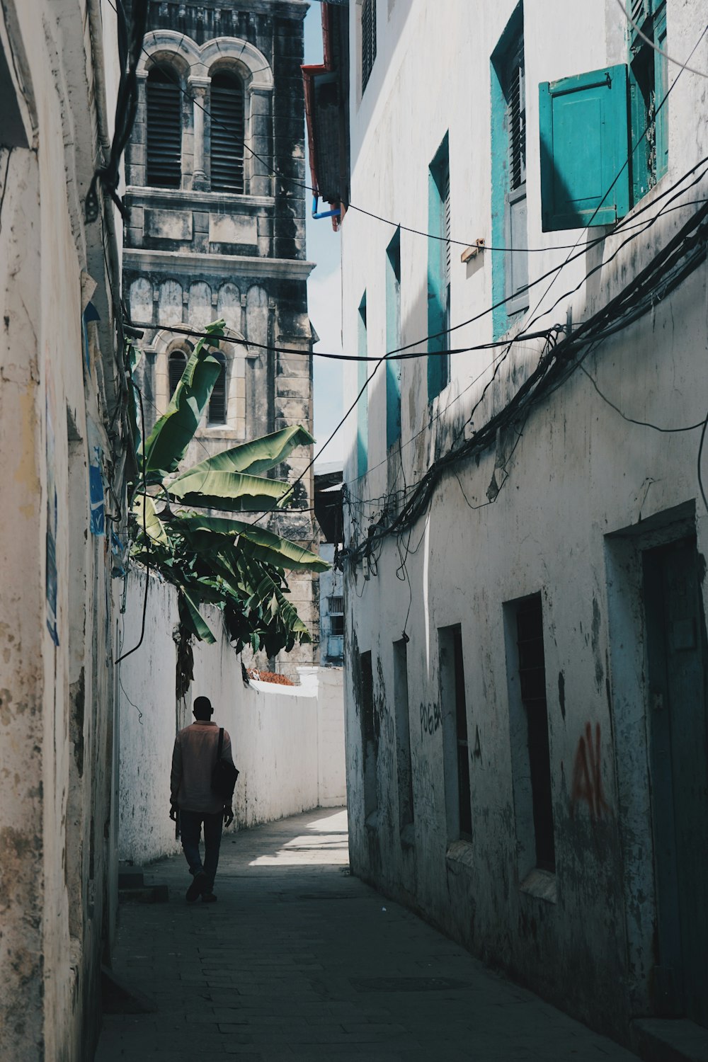 a man walking down a narrow alley way