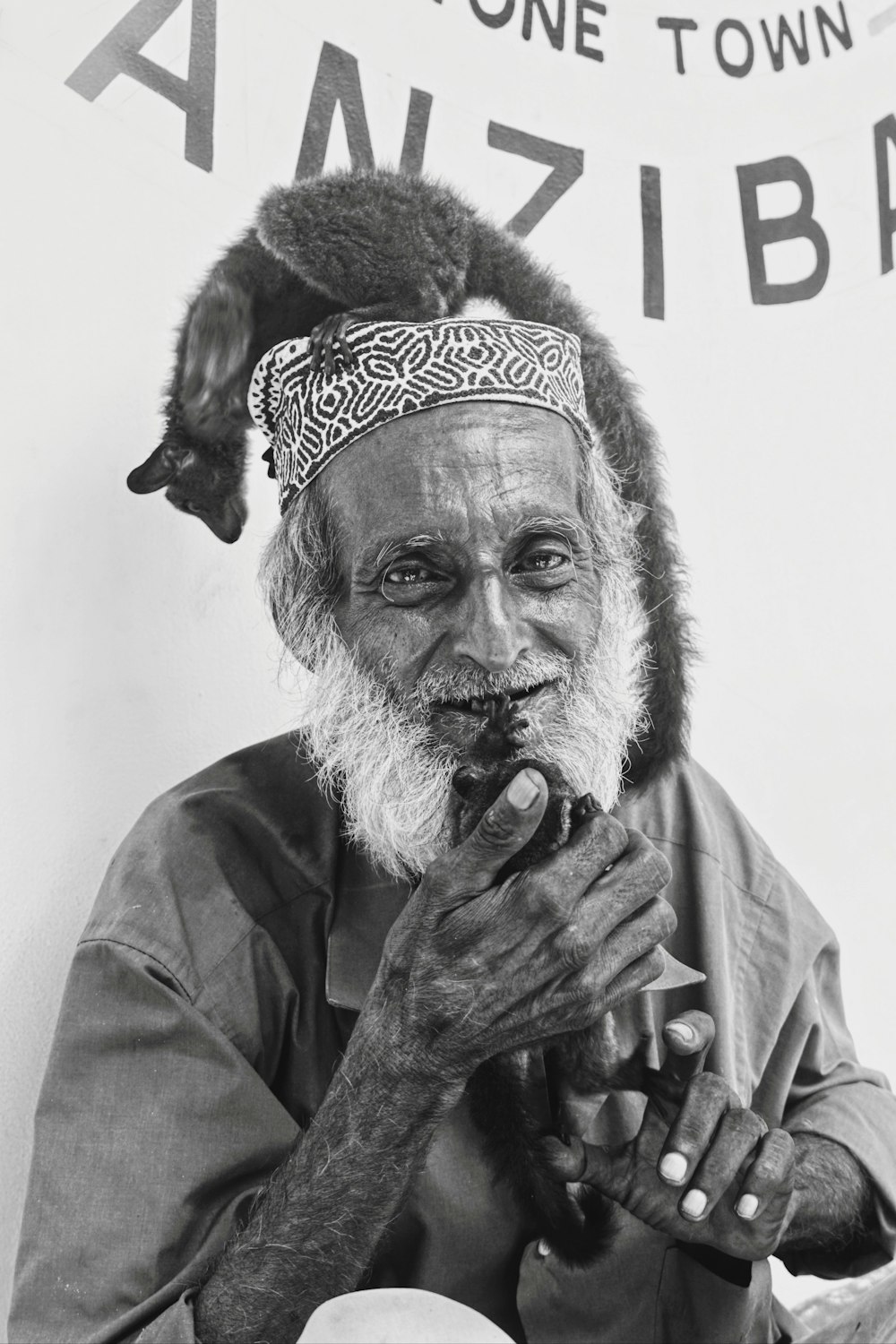 a black and white photo of a man with a cat on his head