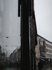 A moody film still showing a solitary figure against a dark urban background.