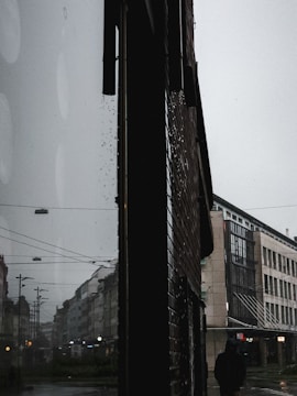 A moody film still showing a solitary figure against a dark urban background.