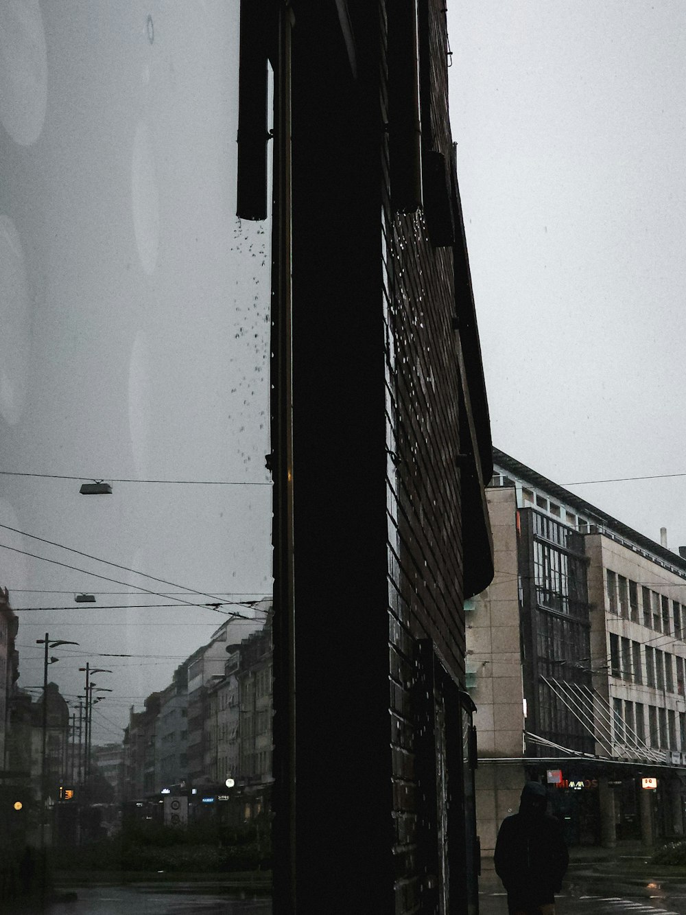 a man walking down a street next to a tall building