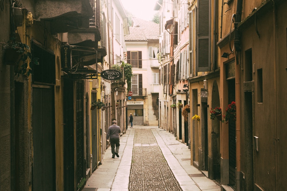 a man walking down a narrow alley way