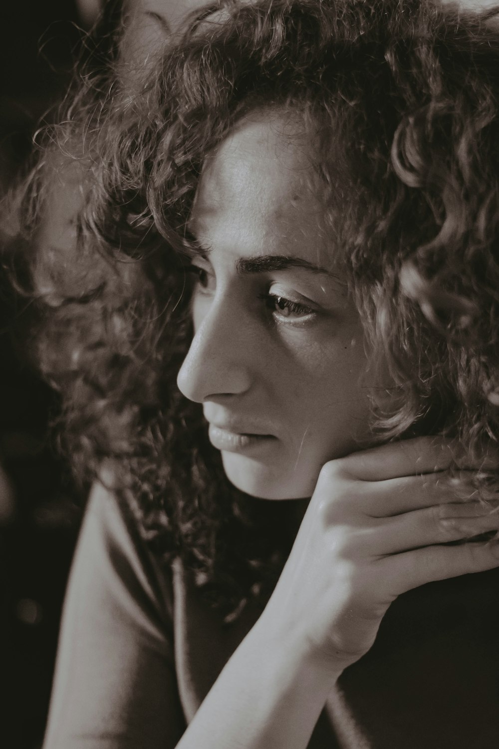 a black and white photo of a woman with curly hair