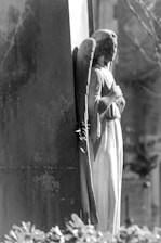 Soft grayscale image of a serene angel statue bathed in gentle light