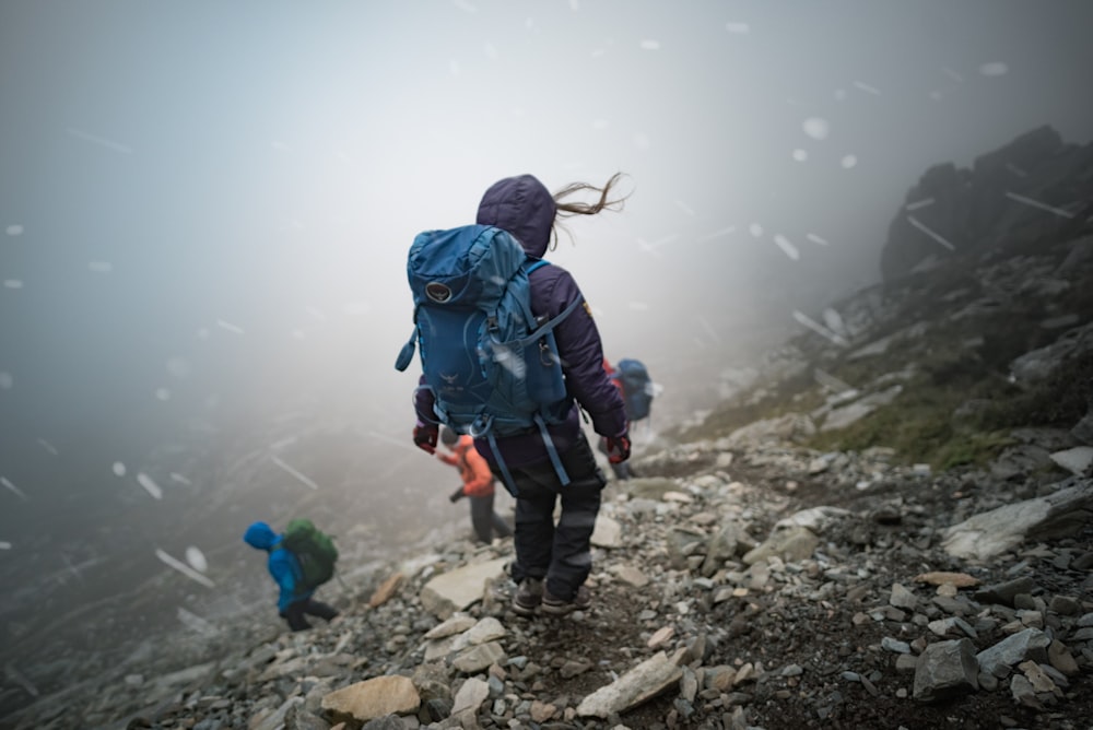 a person with a backpack walking up a rocky hill