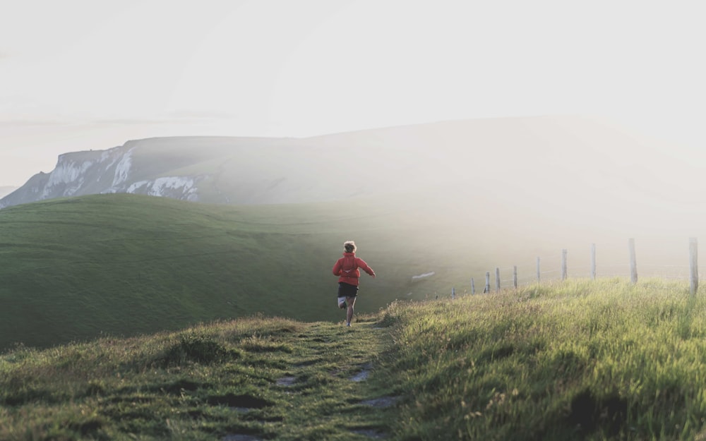 a man running down a trail in the mountains