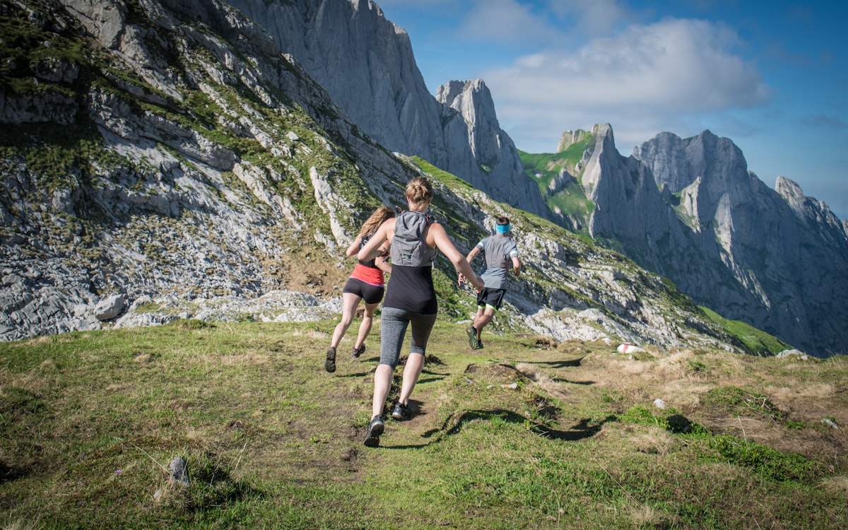 A group of runners hiking up a mountain trail