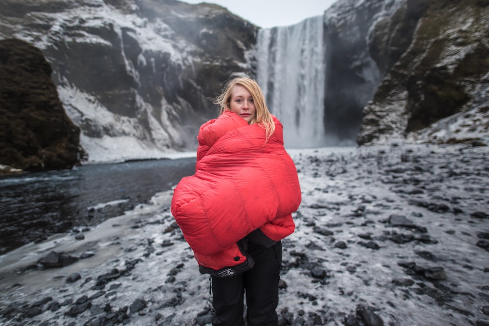 a woman standing in front of a waterfall