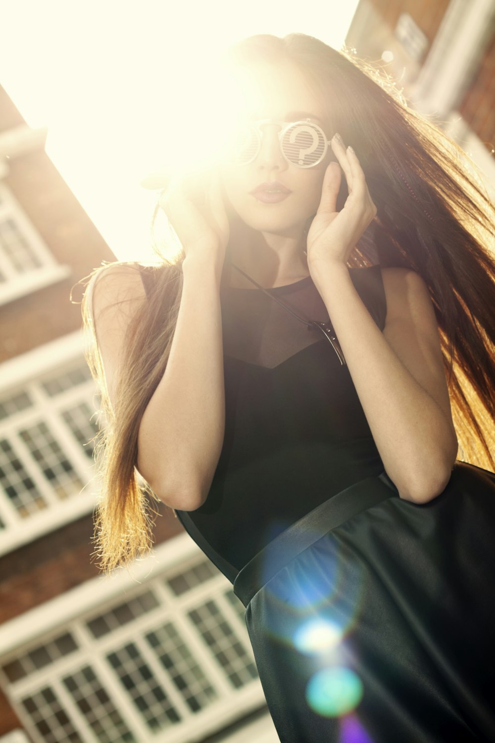 a woman in a black dress talking on a cell phone