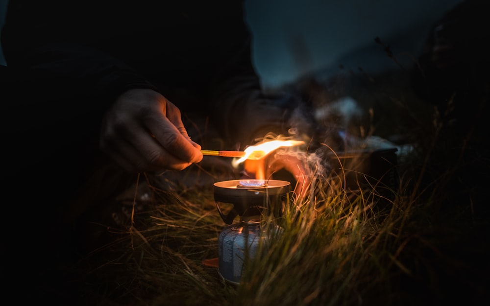 a person lighting a candle in the grass