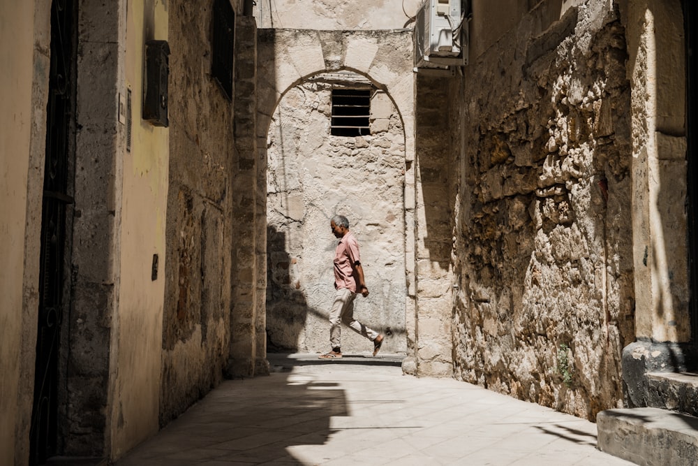 a person walking down a narrow alley way