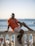 a man sitting on a railing next to the ocean