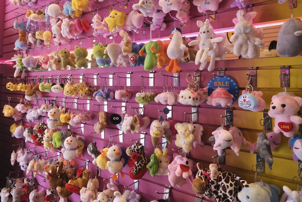 a bunch of stuffed animals are hanging on a wall